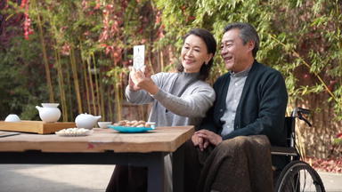 <strong>老</strong>年夫妇在庭院使用手机