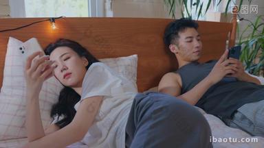 <strong>青年</strong>情侣躺在床上各自玩手机