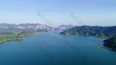 在大坝地区的山崖之间的湖面上的空中景观。绿化峡谷景观4K高质影像画面