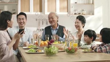<strong>三代</strong>亚洲人快乐的家庭，一边在家里吃饭一边享受时光