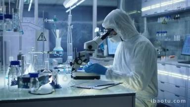 在一个安全的高水平研究实验室科学家在套装调整样品用钳子的培养皿中，然后检查他们显微镜下.