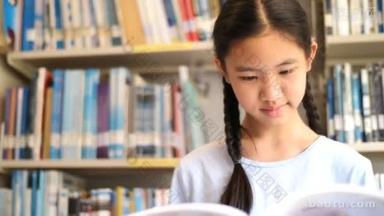4k. 亚洲学生在学校图书馆读一本书是为了灵感, 用自然光线拍摄, 慢动作拍摄