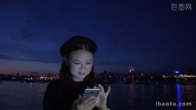 烟花和快乐的女孩使用手机在堤防