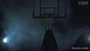 身穿红色制服的年轻篮球运动员把球扔在烟雾弥漫的黑暗背景下的篮筐里。 职业篮球<strong>比赛</strong>选手在行动. 体育的概念