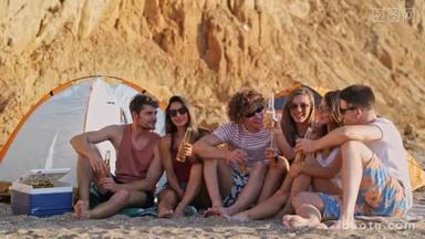 一群年轻的快乐朋友喝啤酒，在<strong>海边</strong>的海滩上玩得很开心