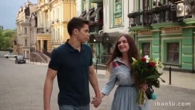 快乐的年轻潮夫妇一起消磨闲暇，<strong>迷人</strong>的女人拿着花束，手牵着她英俊的男人走