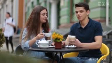 <strong>迷人</strong>的潮人情侣坐在路边咖啡馆的桌子旁，聊着假期旅行中的<strong>浪漫</strong>情侣