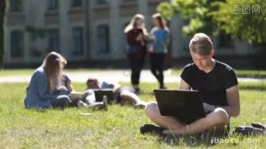 <strong>迷人</strong>的青少年潮坐在绿色的草地在校园草坪，而学习户外英俊的大学生使用笔记本电脑，而