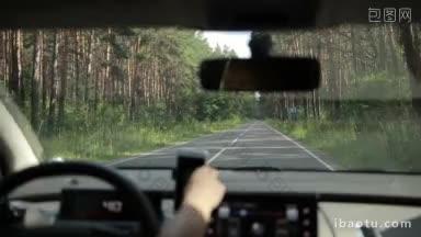 汽车行驶在乡村道路上，<strong>穿过</strong>汽车内部的森林景观
