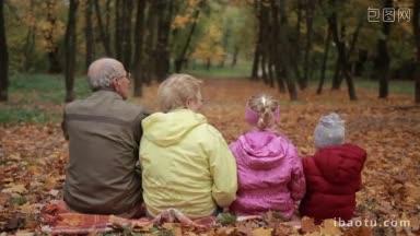 背面正面的多代家庭互相<strong>拥</strong>抱，而<strong>坐</strong>在黄色的落叶在公园的色彩斑斓