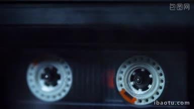 一只手将一盘音乐磁带放进录音带，开始播放
