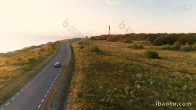 从空中拍摄的驾驶黑色汽车在海边悬崖附近的<strong>乡村</strong>道路上行驶