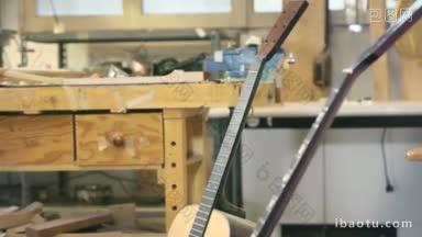 年轻人在工作中作为匠人在车间与吉他和乐器架重点