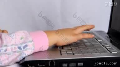 小孩在笔记本电脑<strong>键盘</strong>上打字