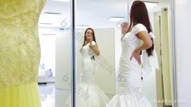 年轻迷人的新娘在婚纱店试穿婚纱