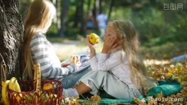两个金发碧眼的小女孩在树下享受阳光明媚的秋日，一边看书一边吃苹果