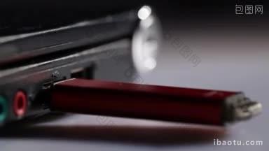 在笔记本电脑上<strong>插入</strong>红色usb闪存驱动器，对焦强调它的微距镜头