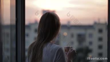 年轻女孩在阳台上看日落和喝茶的中间镜头