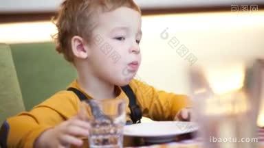 小男孩在咖啡馆的桌子上吃饭，他选择食物，妈妈<strong>给</strong>他的权利