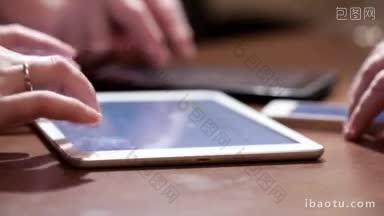 三个使用触屏设备的人在两个触屏板和一部智能手机上打字