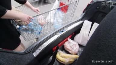 一名妇女在超市购物后，把装在塑料袋和纸袋里的食品杂货卸进汽车后备箱
