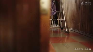 拍摄老妇人借助助行器在家中走廊缓慢移动的镜头
