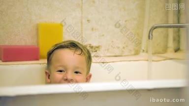 快乐的小男孩坐在浴缸里，水从水龙头里流出，孩子的脸半掩着