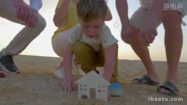 斯坦尼康拍摄的一个小男孩在沙子上安装一个塑料房屋的数字，他的父母和祖父母正在帮助