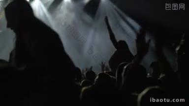 慢镜头是摇滚或流行音乐会上快乐的观众在明亮的聚光灯下鼓掌和挥手