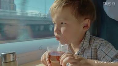 乘火车旅行的小男孩喝着<strong>茶</strong>，望着窗外
