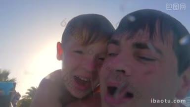 在明亮的阳光下，孩子和他的爸爸深吸一口气跳入游泳池的慢镜头