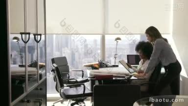 两位建筑师在现代化的办公楼里坐在<strong>桌子上</strong>，拿着蓝图和住房项目
