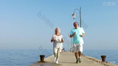 斯坦尼康拍摄的高级男子和妇女沿着码头跑步，他们使用智能手机和戴着耳机听
