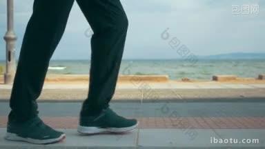 慢动作斯坦尼康拍摄的一个人沿着<strong>海滨</strong>奔跑，只有腿和脚可以看到