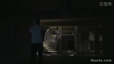 慢动作斯坦尼康拍摄的一个年轻人跑上楼在酒店，他通过几个户外楼梯