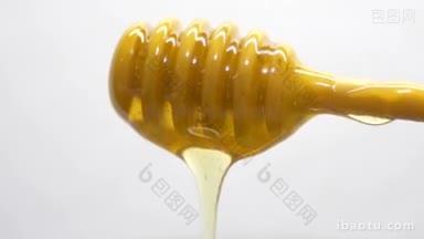 蜂蜜从棍子上滴下来的微距特写