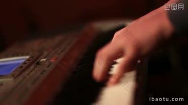 近距离的音乐家的手演奏键盘在派对上聚光灯下少年钢琴家演奏数字钢琴，而摇滚乐队