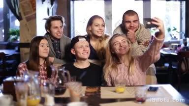 一群美丽的年轻人在咖啡馆用智能手机自拍，微笑着<strong>最好</strong>的朋友，女孩和男孩在一起