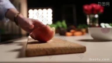 在厨房的砧板上，用漂亮的手用刀切苹果的女人的中间部分