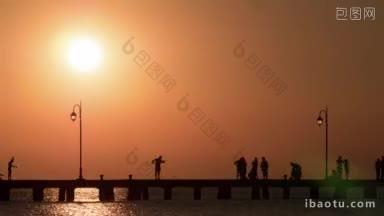 人们在日落和黄昏时走在码头上的时间间隔镜头