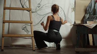 女艺术家蹲工作室有创意的画家创建艺术作品在室内