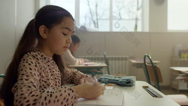 亚洲女孩学习教室学生写作笔记本教训