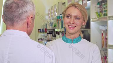 可爱的女化学家微笑快乐会说话的高级的同事