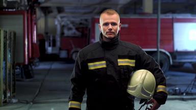消防队员视频肖像穿统一的持有黄色的保护头盔火卡车背景相机移动左
