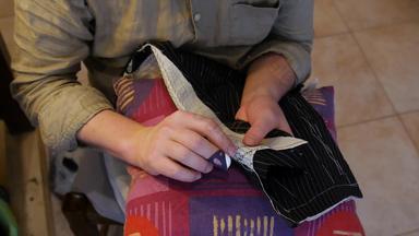 英俊的裁缝裁缝手垫缝合西装翻领垫针西装的翻领运行平行拉佩尔的卷行