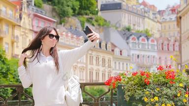 年轻的女人采取肖像Backround美丽的房子欧洲城市高加索人旅游享受欧洲夏天假期欧洲