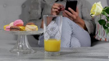 女人智能手机喝橙色汁沙发