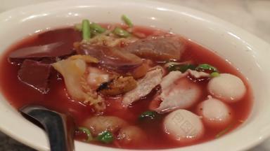 热服务亚洲海鲜面条粉红色的汤