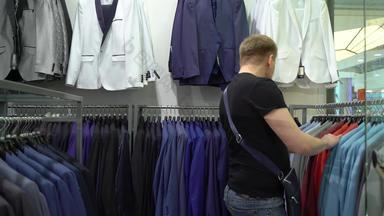 购物时尚概念年轻的男人。选择夹克购物中心