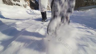 徒步旅行者走路雪冬天扔雪相机低角视图slowmotion